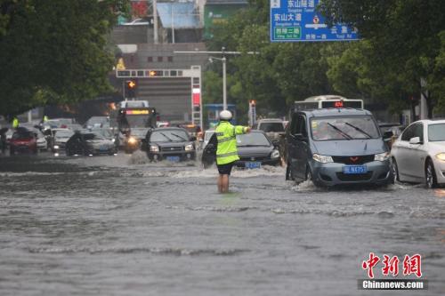 4月22日下午,湖北宜昌突降暴雨,造成市内多路段积水,内涝严重。图为交警在暴雨中指挥交通。朱华刚 摄 今日立夏:南方迎新一轮强降雨 多部门部署防汛