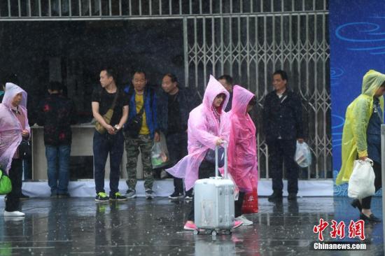 资料图:4月13日,重庆主城区突降暴雨,火车北站北广场上旅客在雨中行走 陈超 摄 暴雨黄色预警:重庆湖北等五省份局地将有大暴雨
