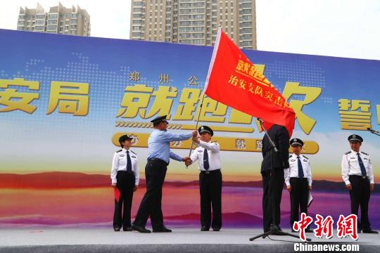 郑州市副市长、市公安局长马义中向治安、交警、出入境等6各部门负责人授旗。 刘鹏 摄 解决办事难、办事慢:郑州千警誓师“就跑一次”