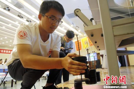 在当天开幕式现场,志愿者向参赛选手演示模型的安装、加载、拆卸等。 沙见龙 摄 全国大学生结构设计竞赛山东赛区开赛 30余支队伍现场角逐