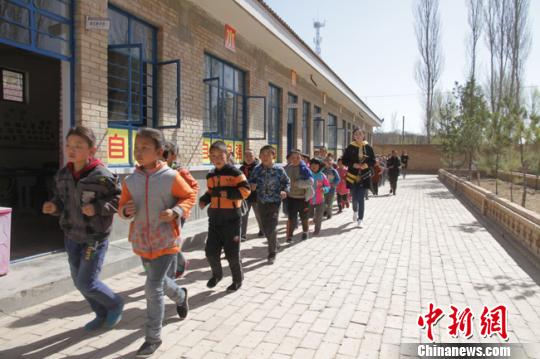 图为“90后”教师武月带领学生跑步。 李文 摄 甘肃庆阳“90后”教师激活乡村小学 引学生返乡上学